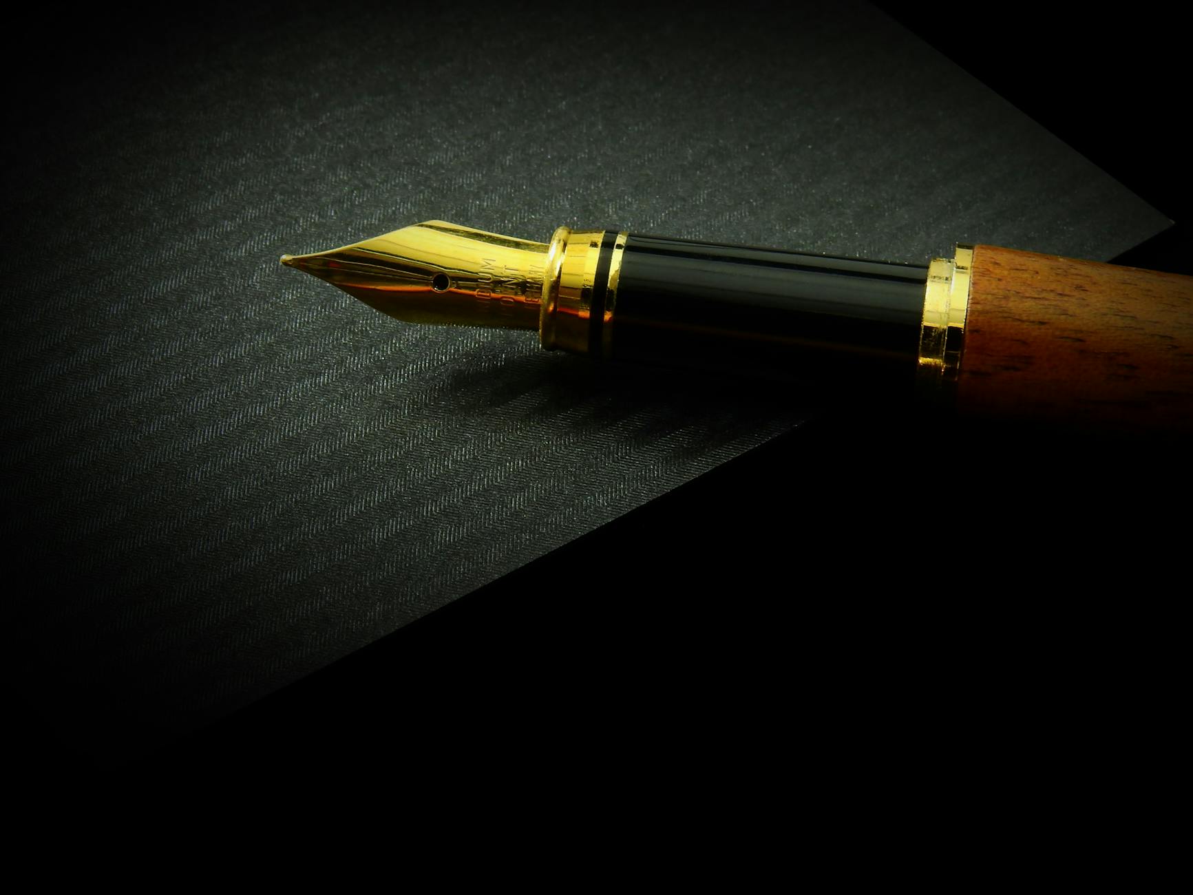 A golden pen on a black background.