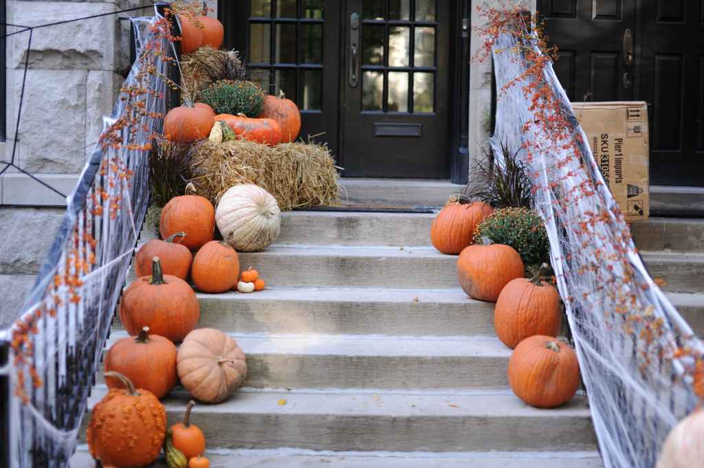 Rows of pumpkins of a house's front steps.