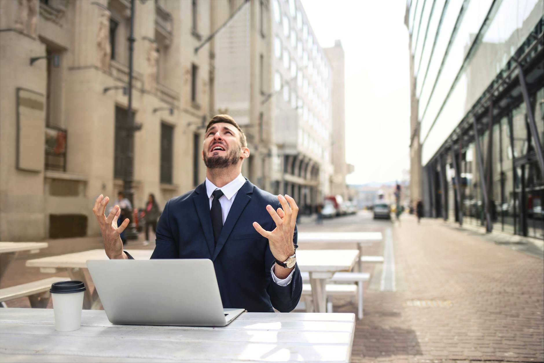 An upset man working on a laptop.