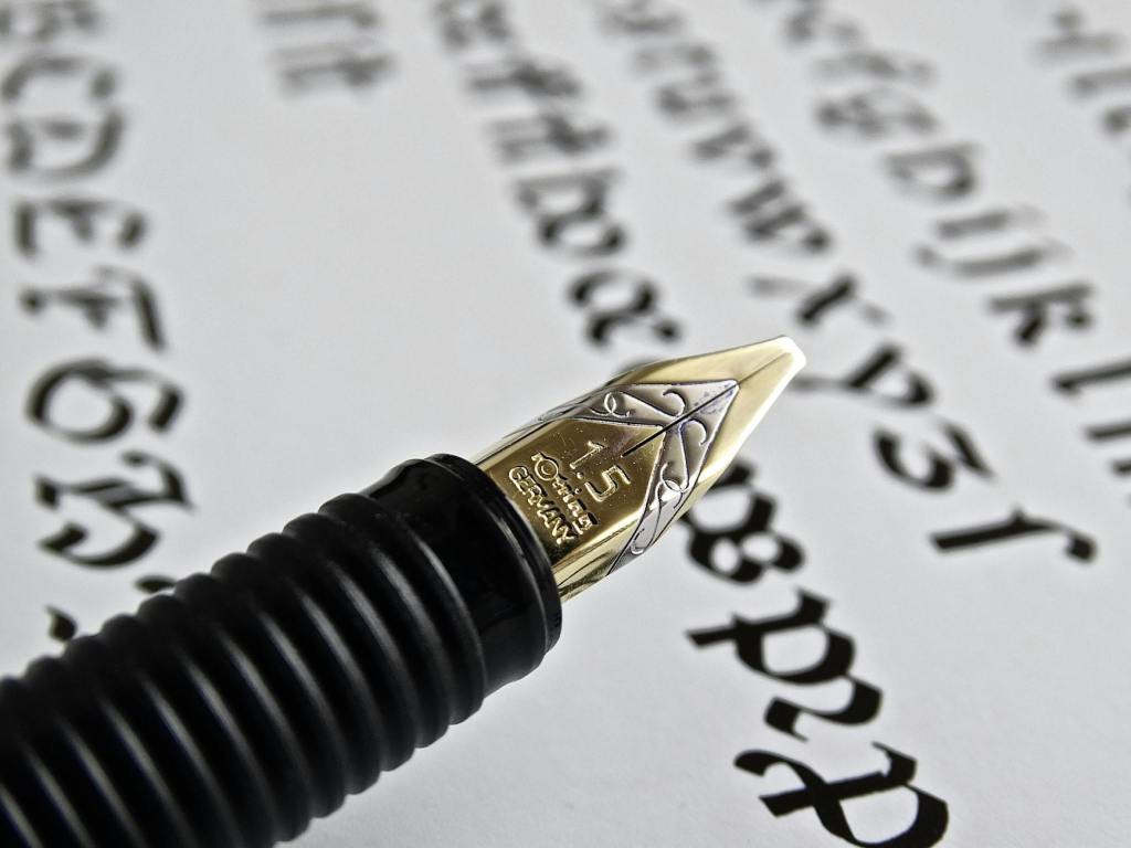 A fountain pen on a page with uncial writing.