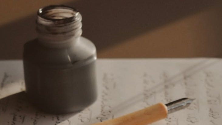 An inkpot and pen on a piece of paper.
