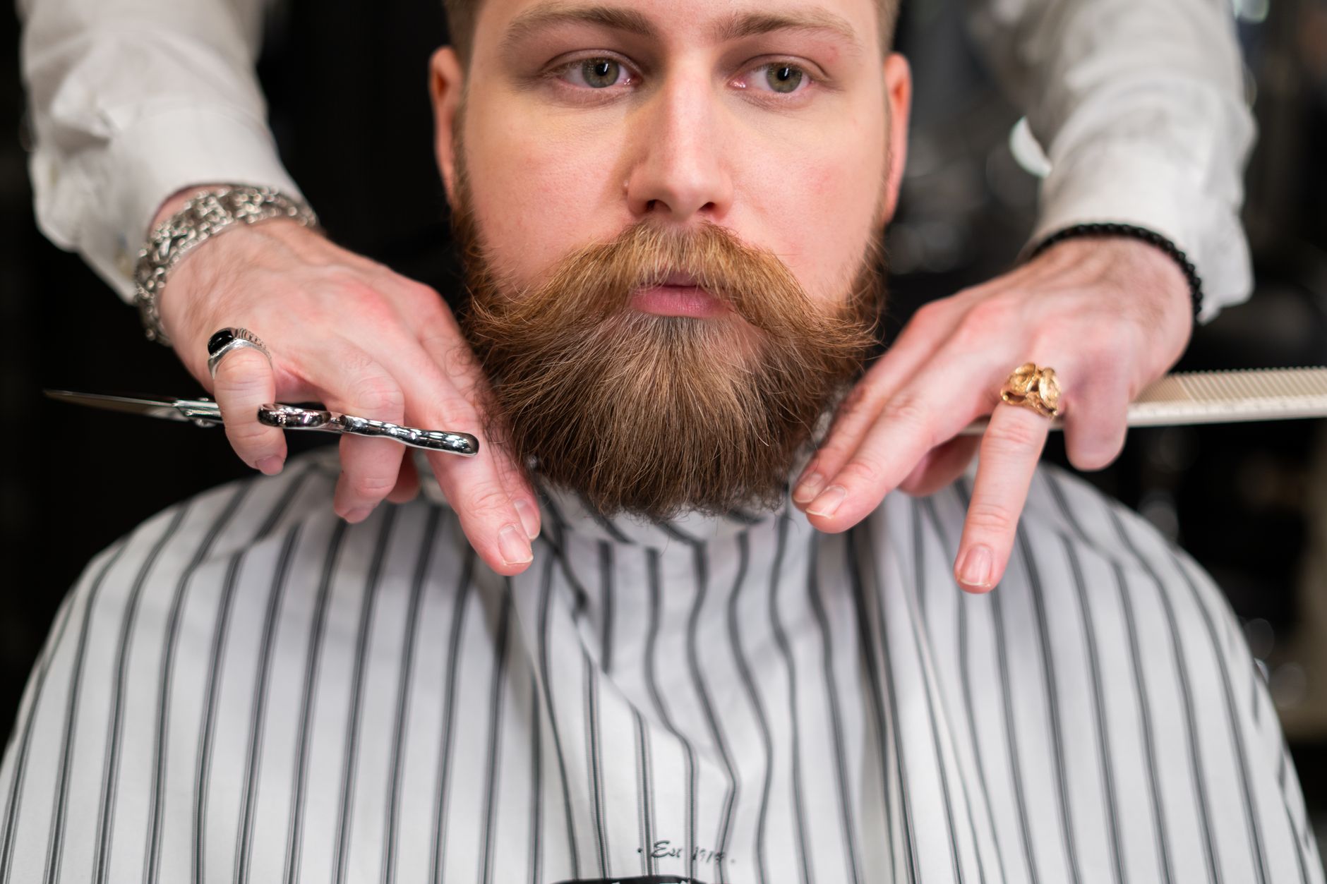 A man with a large moustache at the barber.