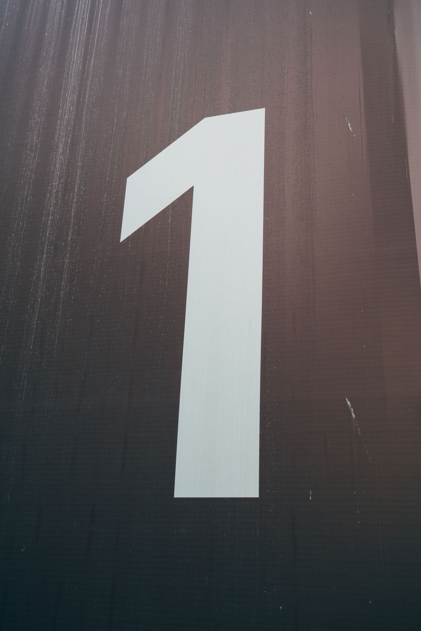 The number one on a wooden background.
