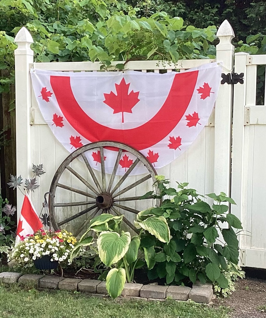 A Canada flag draped over a fence.