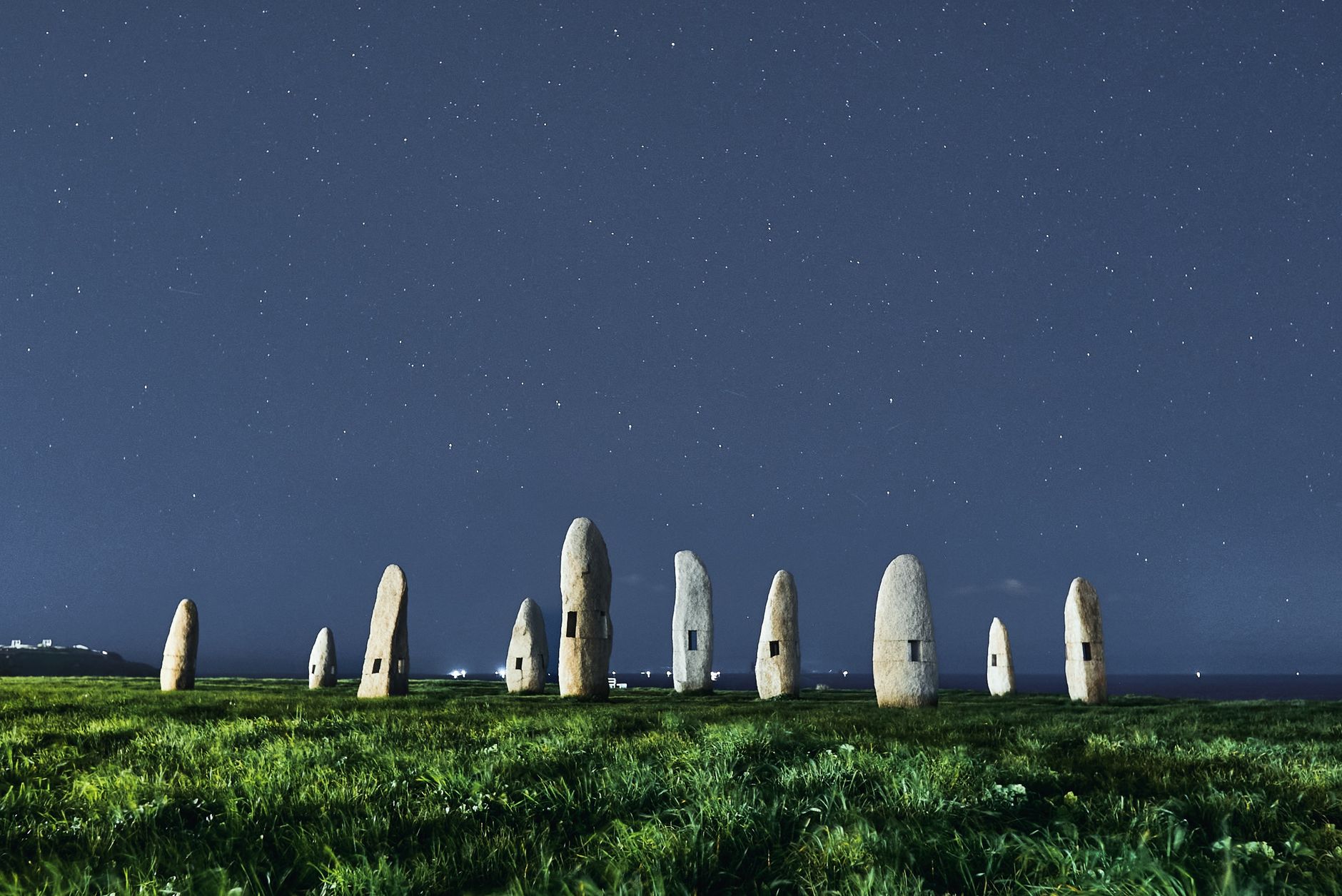 A field of standing stones under a night sky.